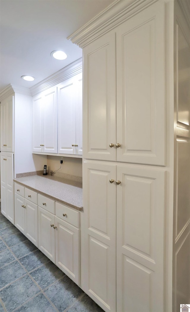 kitchen with white cabinetry and crown molding