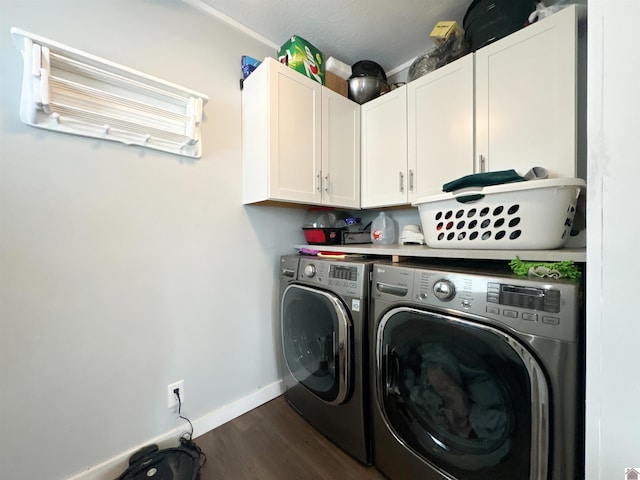 washroom featuring cabinets, dark hardwood / wood-style flooring, and washer and clothes dryer