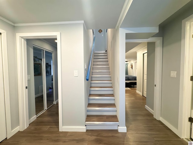 staircase featuring crown molding and hardwood / wood-style flooring