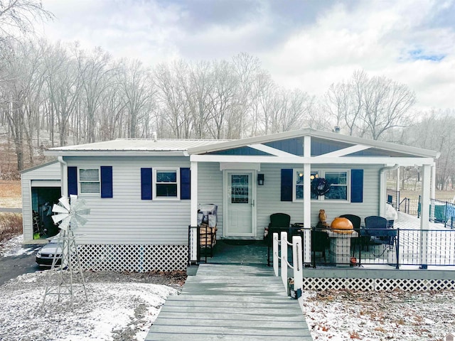 view of front of property featuring covered porch, a garage, and an outdoor structure