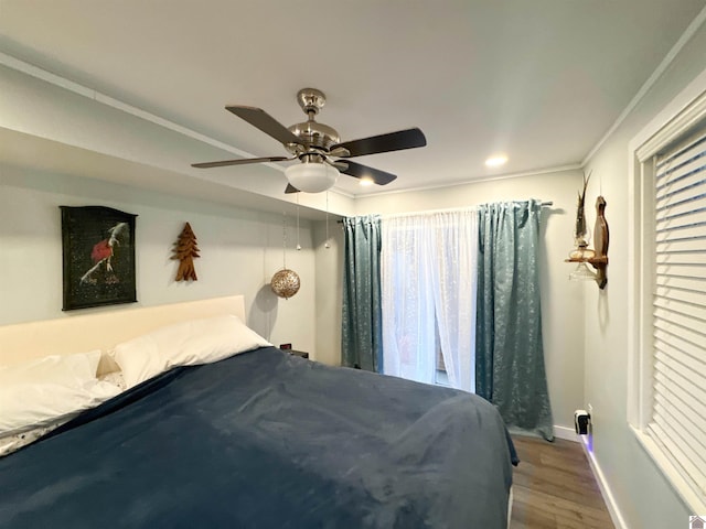 bedroom with hardwood / wood-style floors, ceiling fan, and crown molding