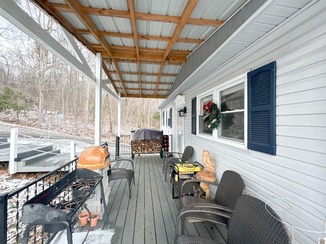 snow covered deck with a grill