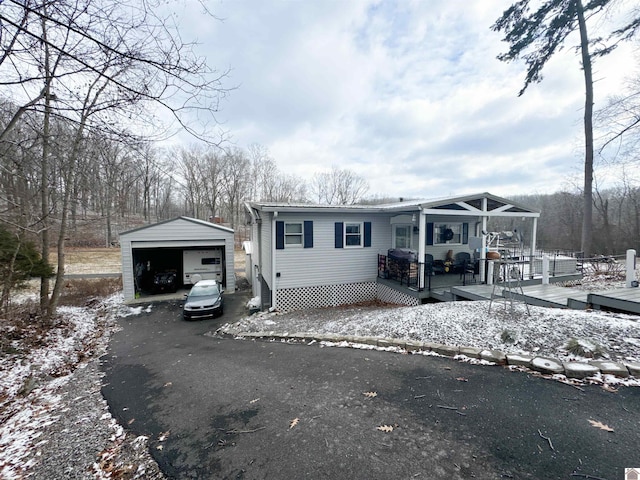 manufactured / mobile home featuring an outdoor structure, a garage, and a deck