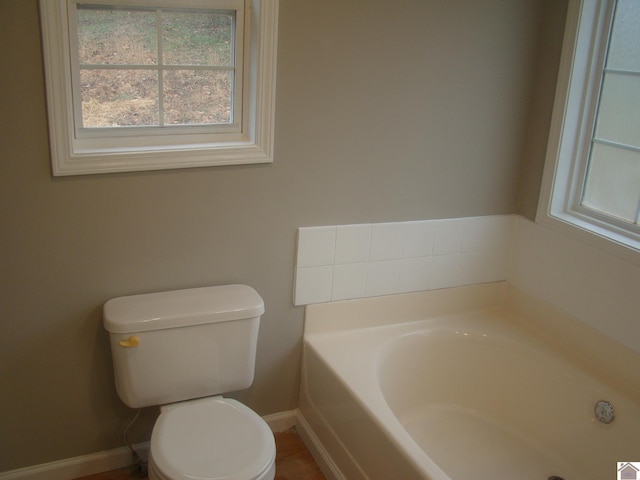 bathroom with toilet and a bath