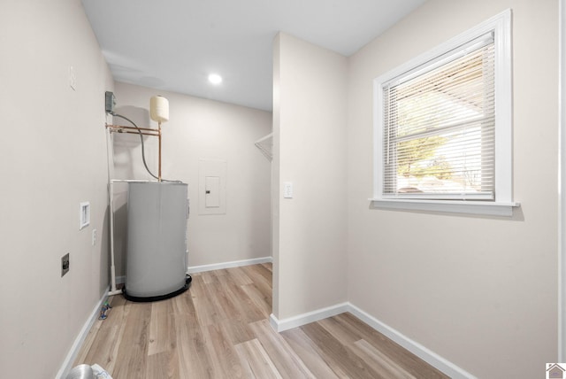 interior space featuring washer hookup, electric dryer hookup, water heater, electric panel, and light wood-type flooring