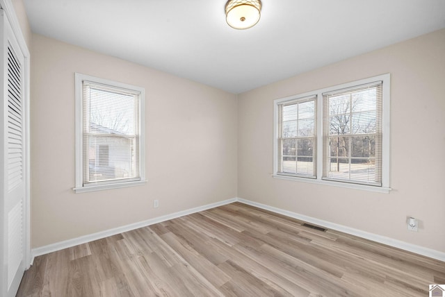 spare room featuring light hardwood / wood-style floors and plenty of natural light