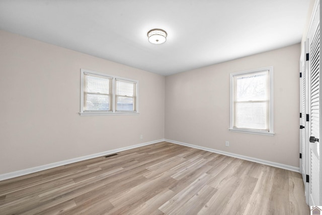 spare room featuring light hardwood / wood-style floors and plenty of natural light