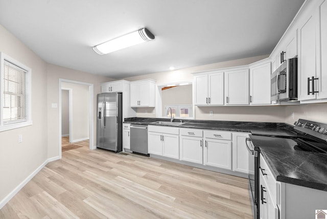 kitchen featuring sink, white cabinets, light hardwood / wood-style floors, and appliances with stainless steel finishes