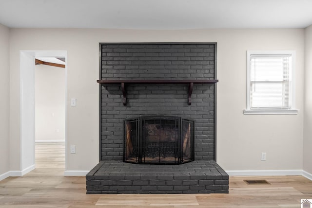 interior details with hardwood / wood-style flooring and a brick fireplace