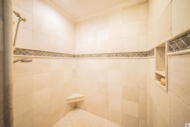 bathroom featuring a tile shower and ornamental molding