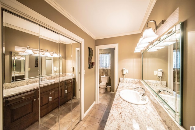 bathroom featuring tile patterned flooring, vanity, toilet, and crown molding