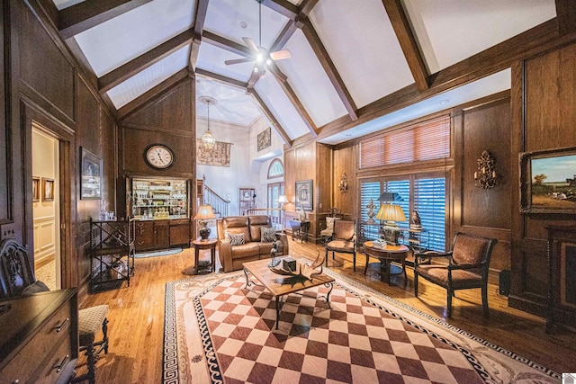 living room featuring beamed ceiling, ceiling fan, high vaulted ceiling, and light hardwood / wood-style flooring