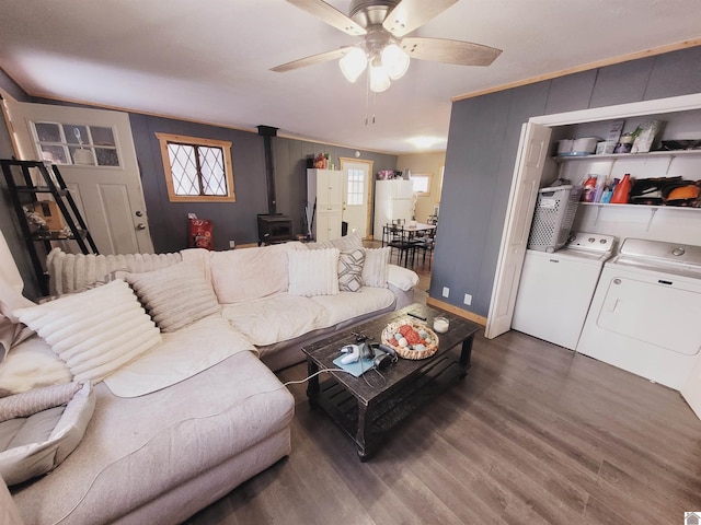 living room featuring a wood stove, separate washer and dryer, ceiling fan, and a healthy amount of sunlight