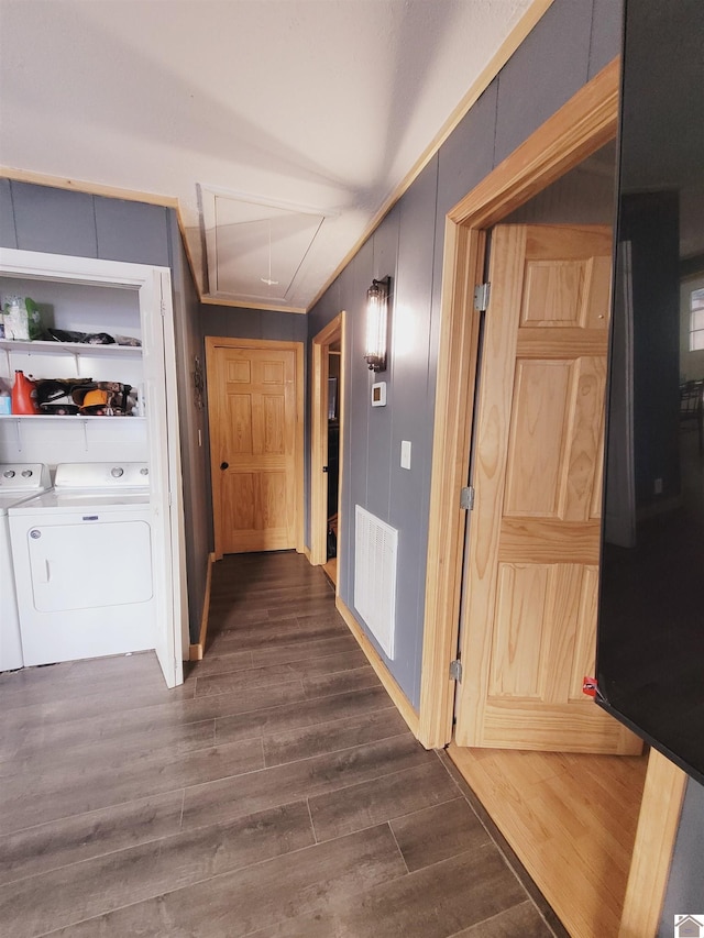 hallway featuring ornamental molding, dark wood-type flooring, and washing machine and clothes dryer