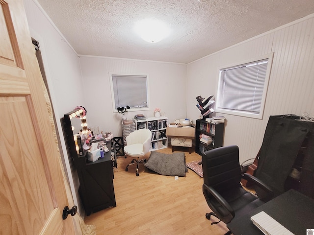 home office featuring light hardwood / wood-style flooring, a textured ceiling, and ornamental molding