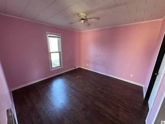 spare room with crown molding, ceiling fan, and dark wood-type flooring