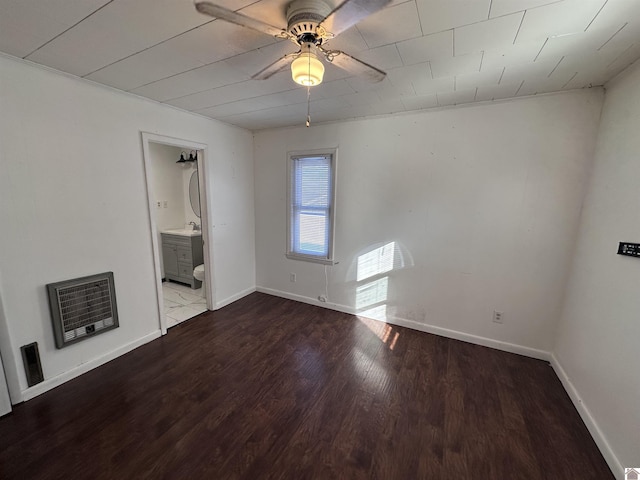 spare room featuring heating unit, ceiling fan, and hardwood / wood-style floors