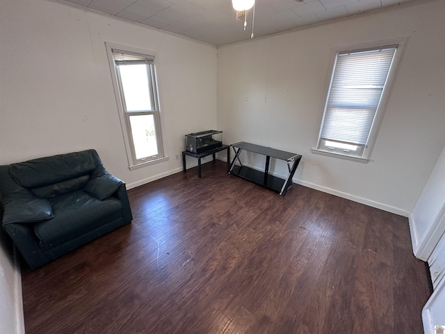 living area featuring ceiling fan and dark hardwood / wood-style flooring