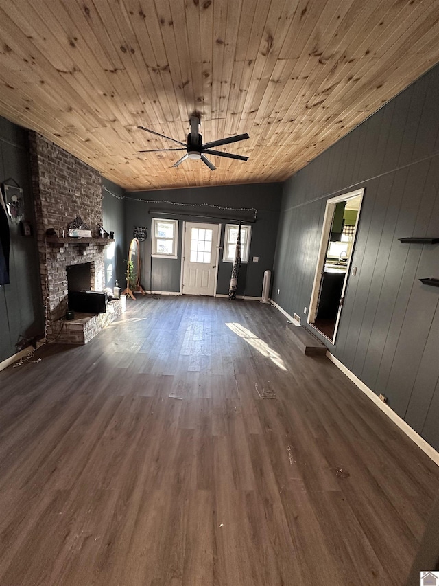 unfurnished living room with wooden walls, a fireplace, wooden ceiling, and hardwood / wood-style flooring