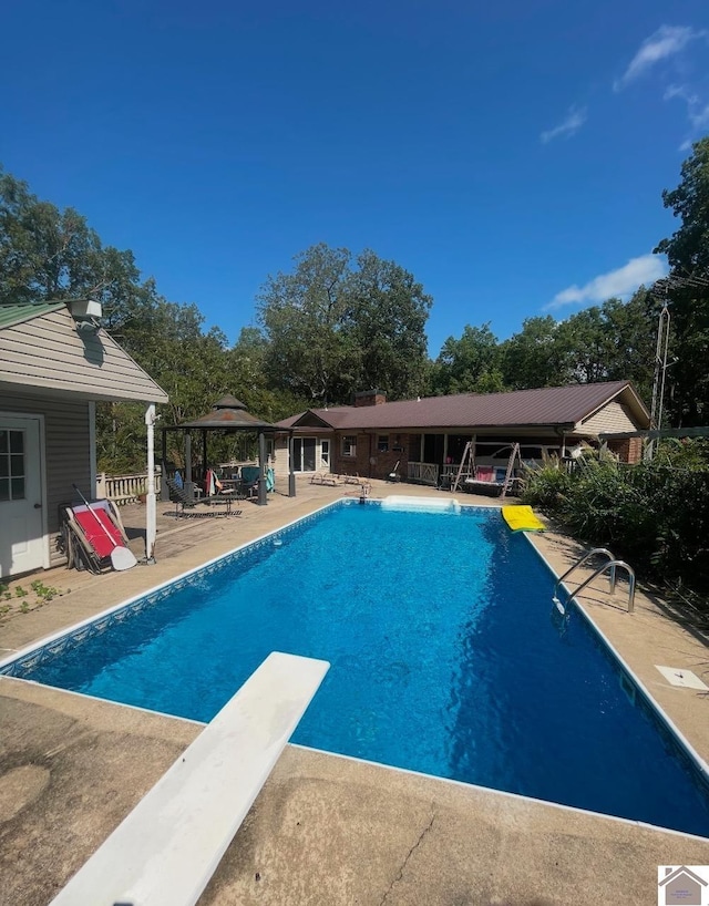 view of pool featuring a gazebo, a diving board, and a patio