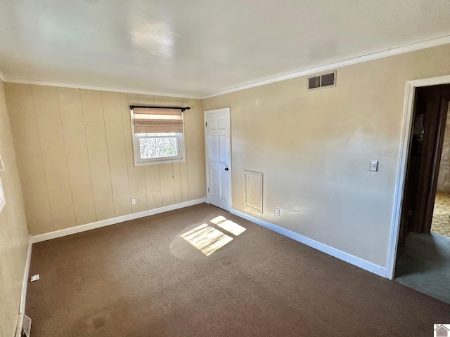 carpeted spare room featuring crown molding