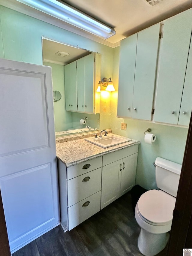 bathroom with hardwood / wood-style flooring, vanity, and toilet