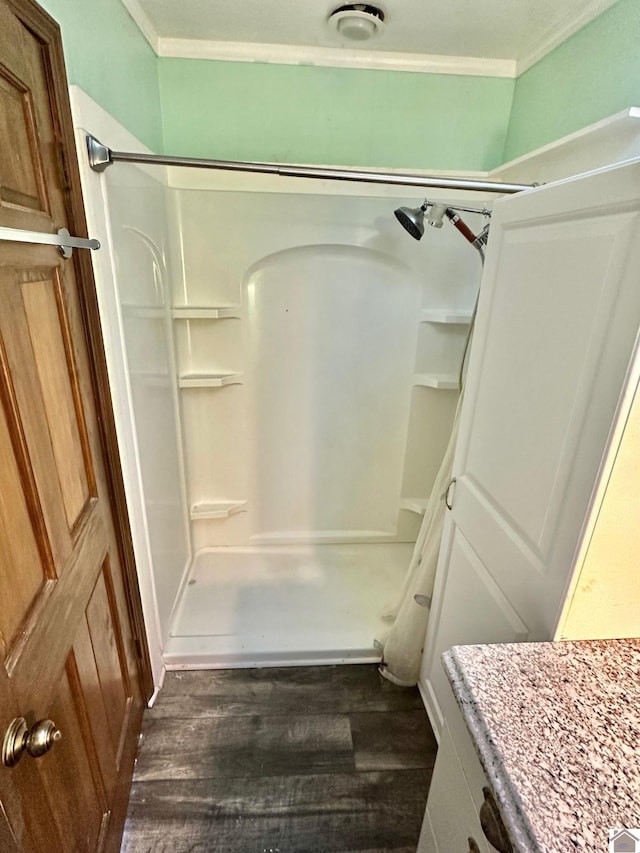 bathroom featuring hardwood / wood-style floors, walk in shower, and crown molding