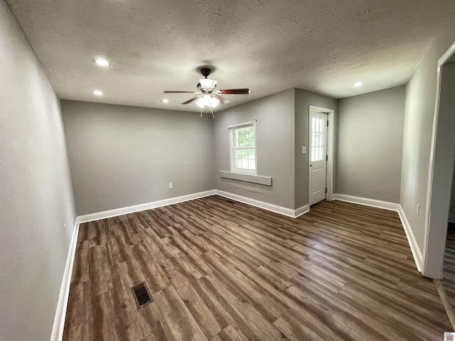 unfurnished room with a textured ceiling, dark hardwood / wood-style floors, and ceiling fan