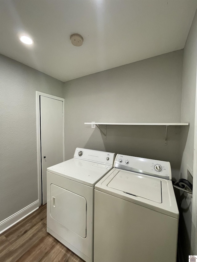 washroom with dark hardwood / wood-style flooring and washer and clothes dryer