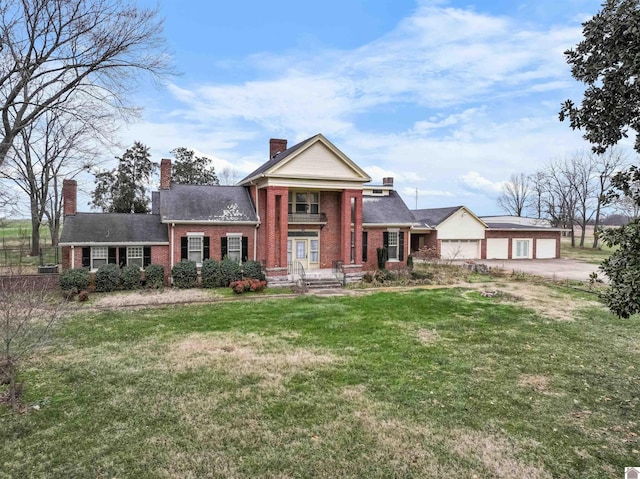 greek revival inspired property featuring a garage and a front lawn