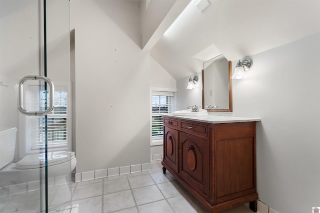 bathroom featuring tile patterned flooring, vanity, toilet, and lofted ceiling