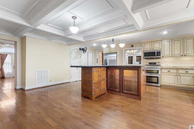 kitchen featuring stone counters, stainless steel appliances, a kitchen island, and hanging light fixtures