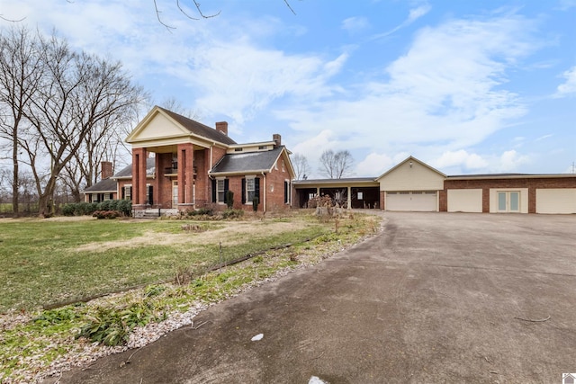 neoclassical / greek revival house featuring a front yard, a porch, and a garage