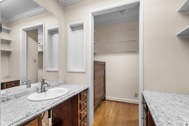 bathroom with crown molding, hardwood / wood-style floors, and vanity