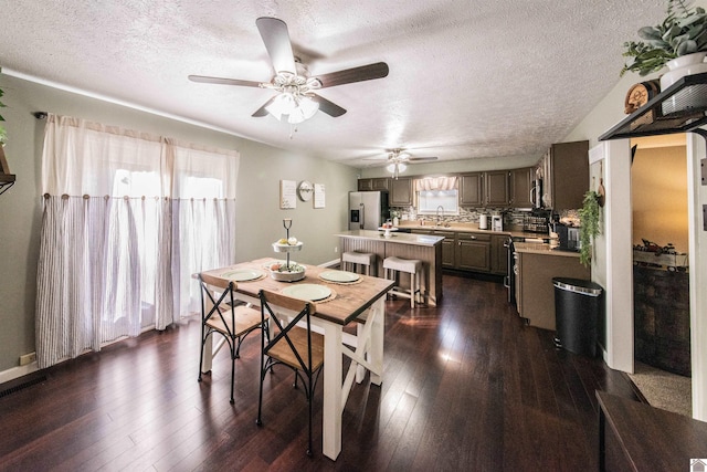 dining area with sink, dark wood-type flooring, and plenty of natural light