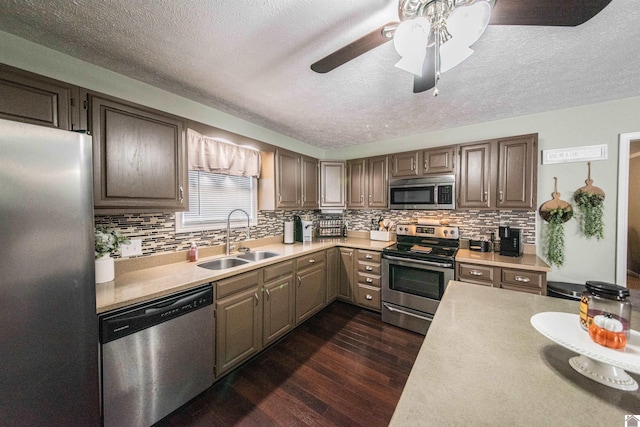 kitchen featuring decorative backsplash, sink, appliances with stainless steel finishes, and dark wood-type flooring