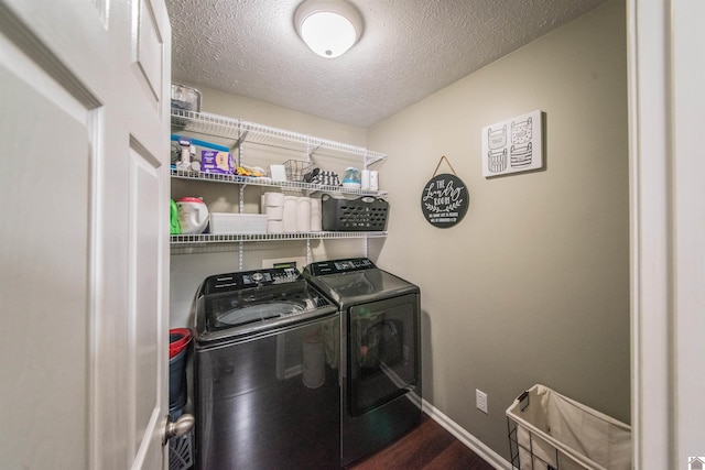 laundry area with washer and dryer, dark hardwood / wood-style flooring, and a textured ceiling