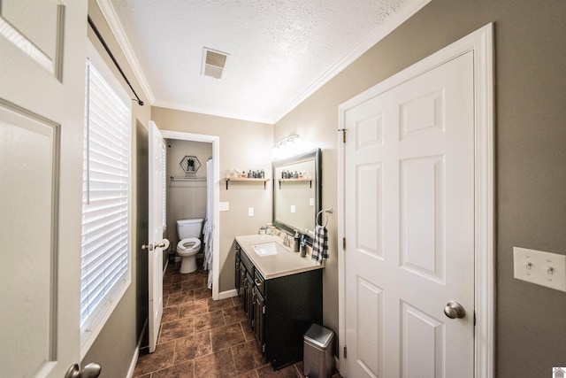 bathroom featuring crown molding, vanity, a textured ceiling, and toilet