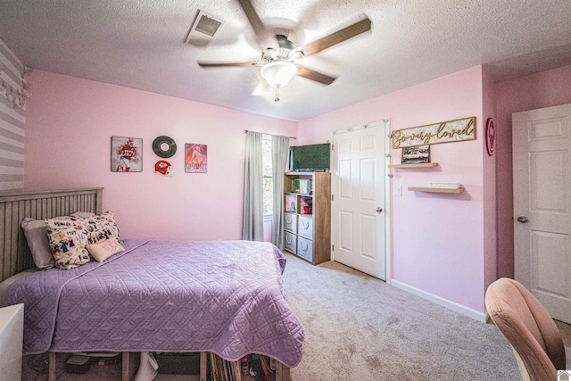 bedroom featuring a textured ceiling, ceiling fan, and light carpet