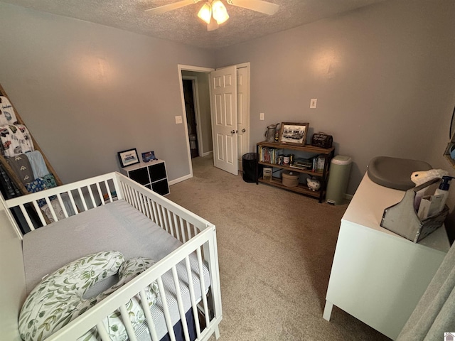 carpeted bedroom featuring a textured ceiling and ceiling fan