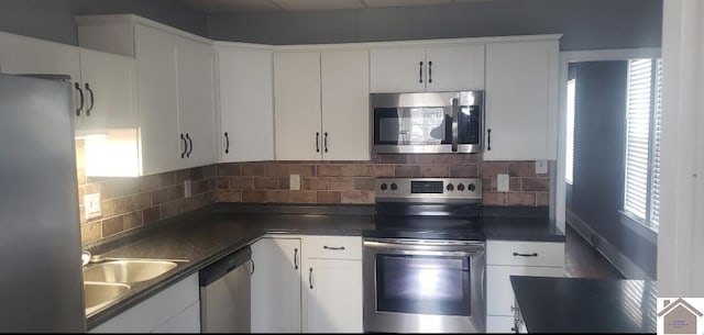 kitchen with stainless steel appliances, backsplash, white cabinetry, and sink