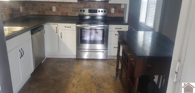 kitchen with sink, white cabinetry, stainless steel appliances, and tasteful backsplash