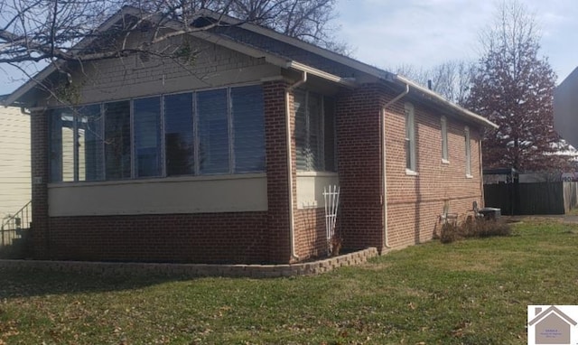 view of side of home with a yard