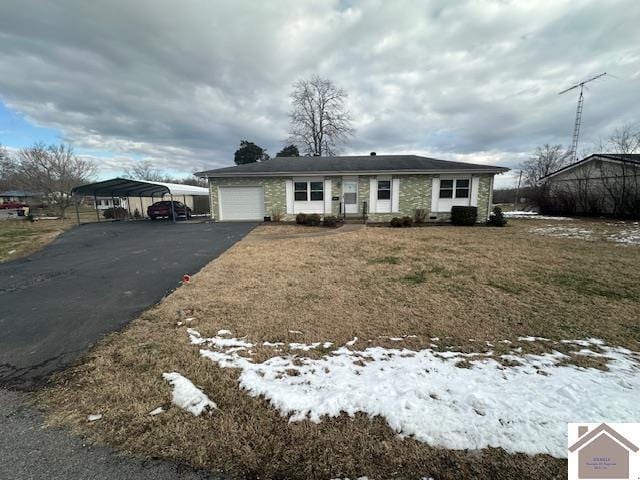 view of front of property featuring a carport, a garage, and a yard