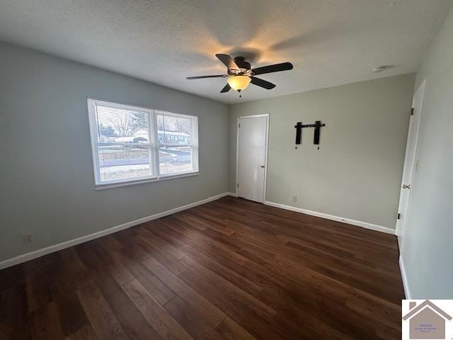 spare room with a textured ceiling, dark hardwood / wood-style flooring, and ceiling fan