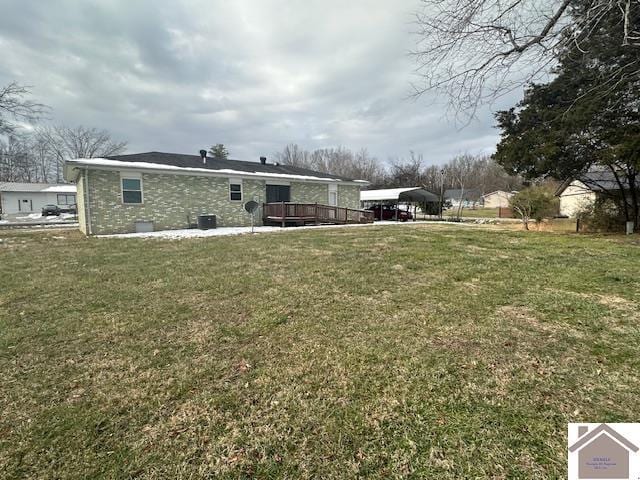 back of house with a lawn, central AC, and a carport