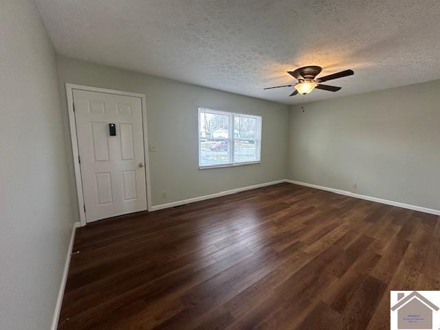 spare room with a textured ceiling, dark hardwood / wood-style floors, and ceiling fan