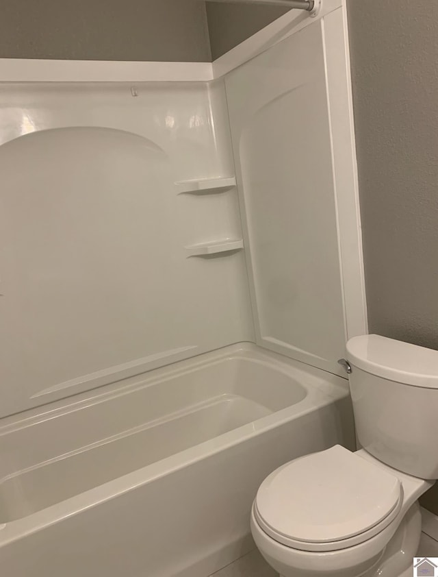 bathroom with tile patterned floors,  shower combination, and toilet