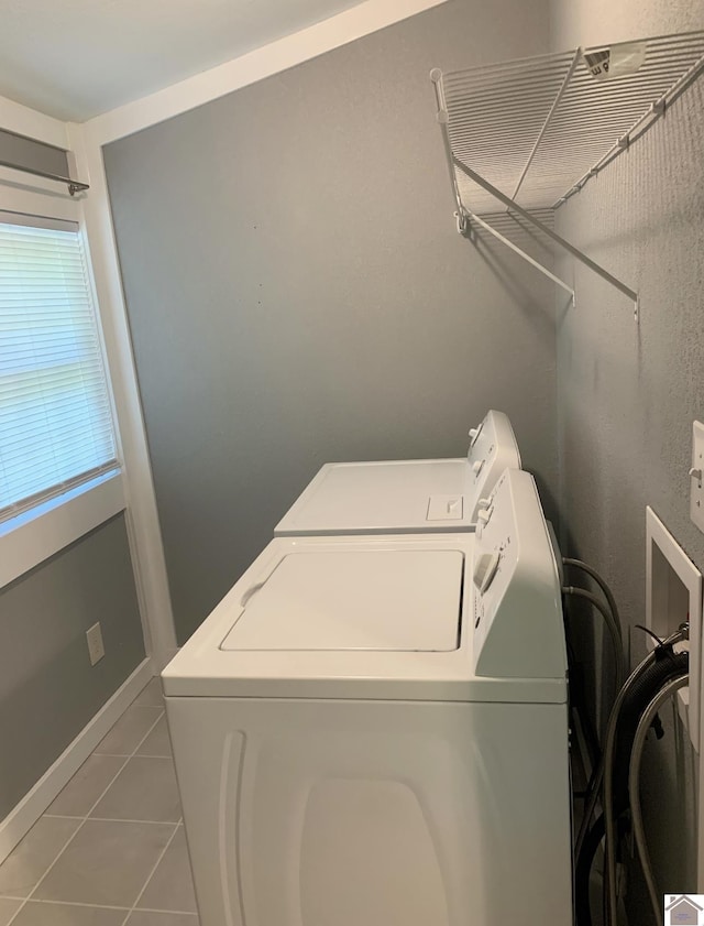 clothes washing area with light tile patterned floors and washing machine and clothes dryer