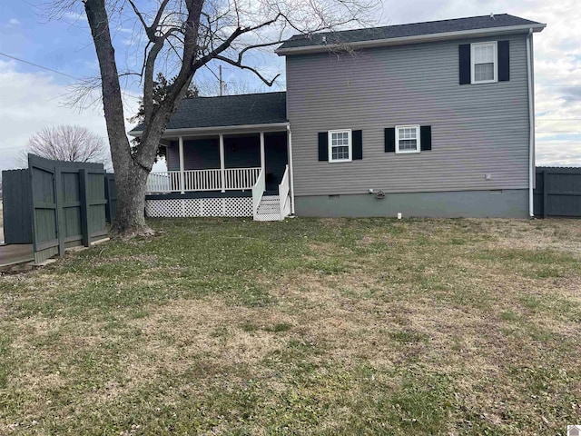 back of property featuring a lawn and covered porch